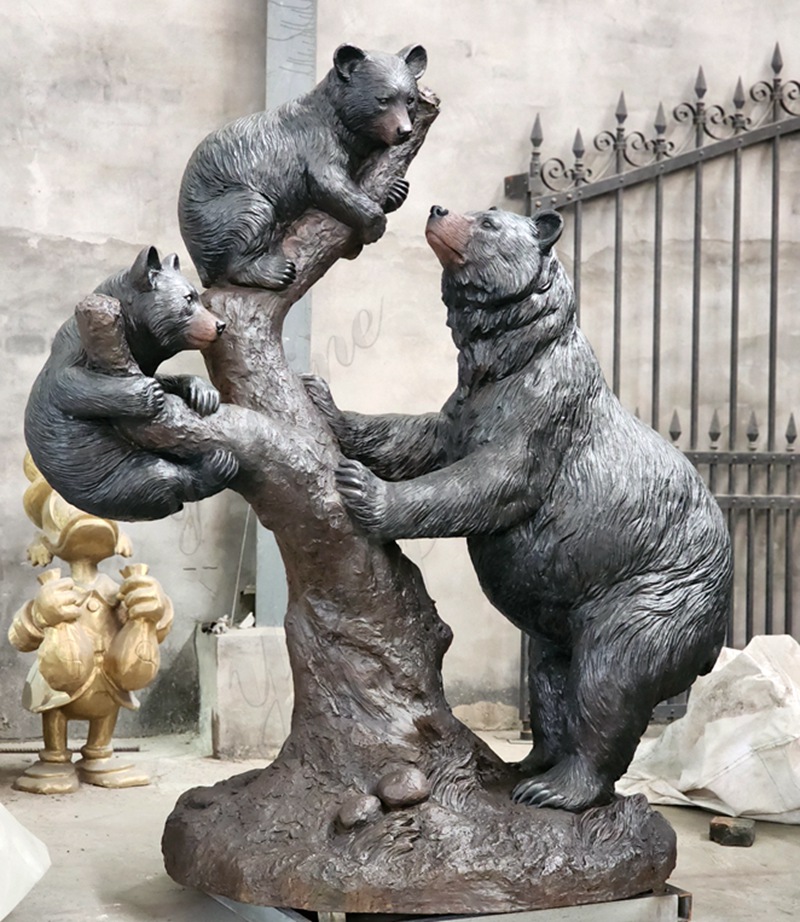 Mother bear and cub sculpture standing on a tree